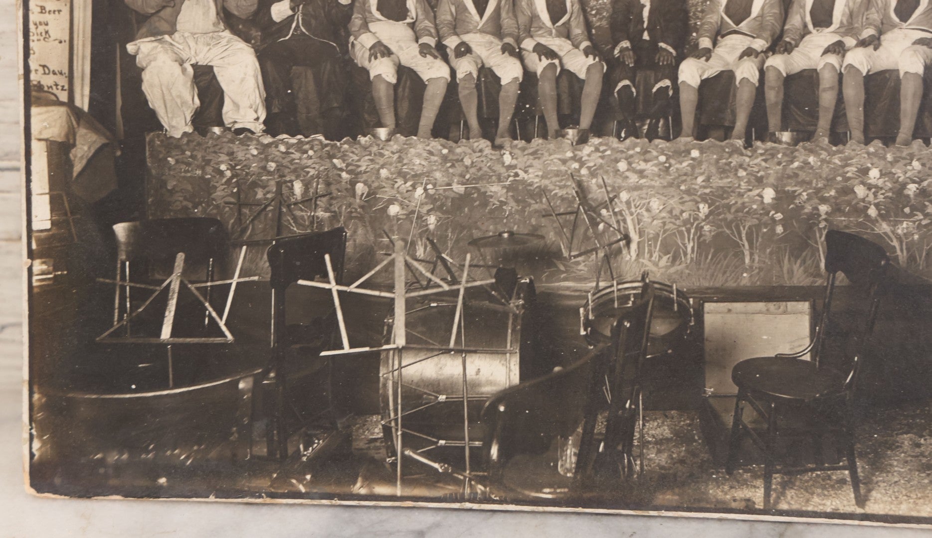 Lot 110 - Antique Boarded Photograph Of Stage Performers In Costume With Painted Backdrop And Drum Set, Music Stands In Foreground