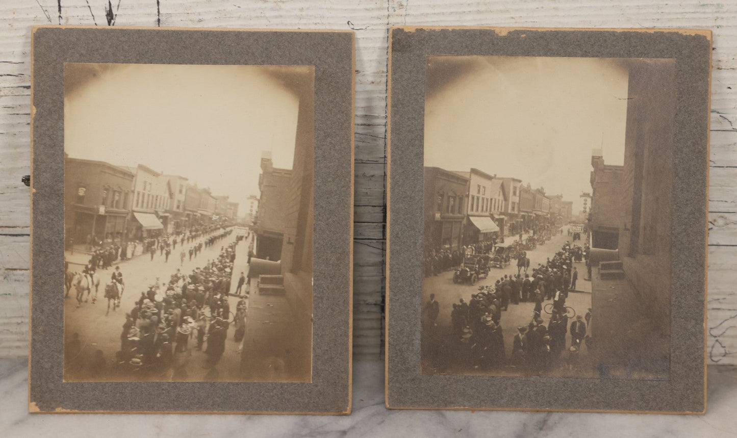Lot 115 - Pair Of Antique Boarded Photographs Of Parade And Onlookers With Early Automobiles And People On Horseback Signs For "Red Front Store" And "National Bank"