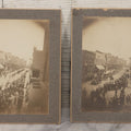 Lot 115 - Pair Of Antique Boarded Photographs Of Parade And Onlookers With Early Automobiles And People On Horseback Signs For "Red Front Store" And "National Bank"
