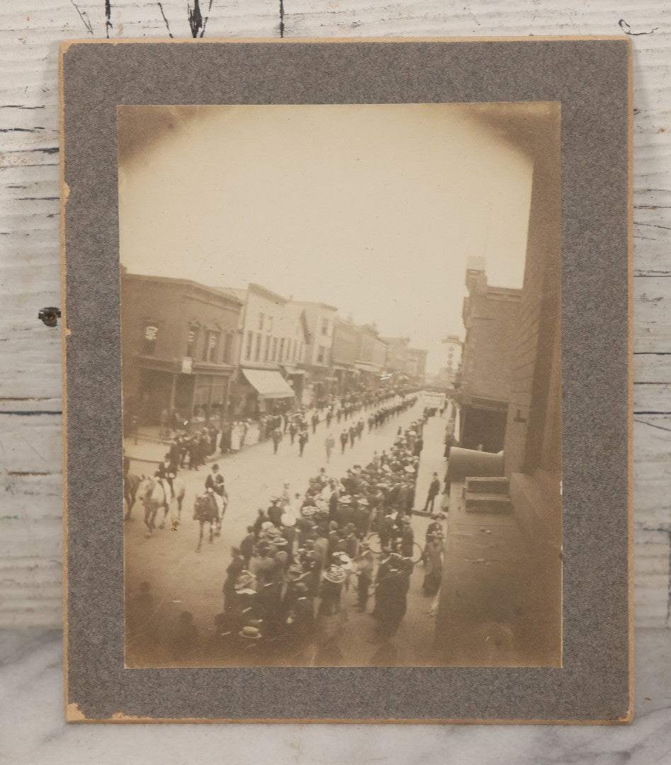 Lot 115 - Pair Of Antique Boarded Photographs Of Parade And Onlookers With Early Automobiles And People On Horseback Signs For "Red Front Store" And "National Bank"