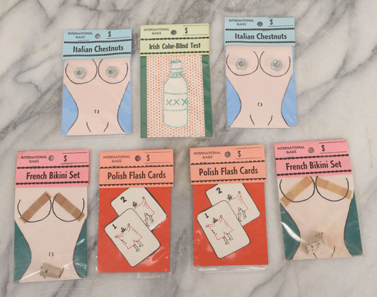 Lot 047 - Grouping Of Seven Vintage "International Gags" Offensive Stereotype Novelty Jokes, Including Italian Chestnuts, French Bikini Set, And Polish Flashcards, Wade Enterprises, East Granby, Connecticut