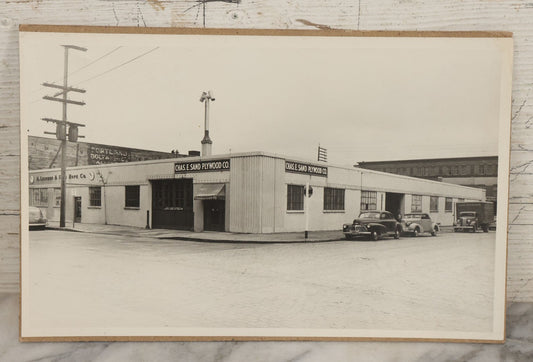 Lot 120 - Vintage Large Format Photograph Of The Chas. E. Sand Plywood Co. With 1930s Automobiles And Painted Advertising For Portland Bolt Manufacturing Company, St. Louis Missouri