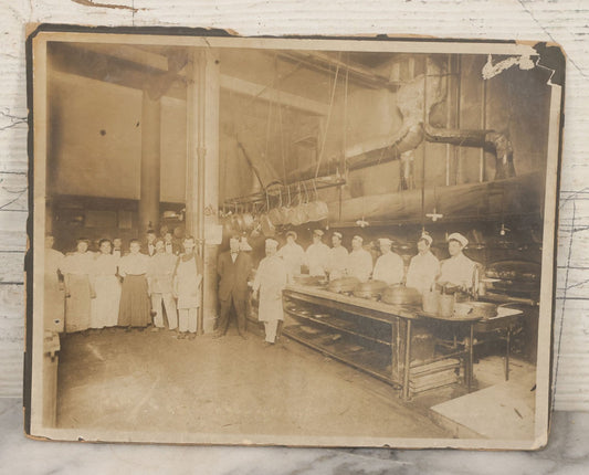 Lot 124 - Antique Boarded Occupational Photograph Of Kitchen Staff At Their Stations In Large Industrial Kitchen With Period Uniforms And Cooking Appliances Visible