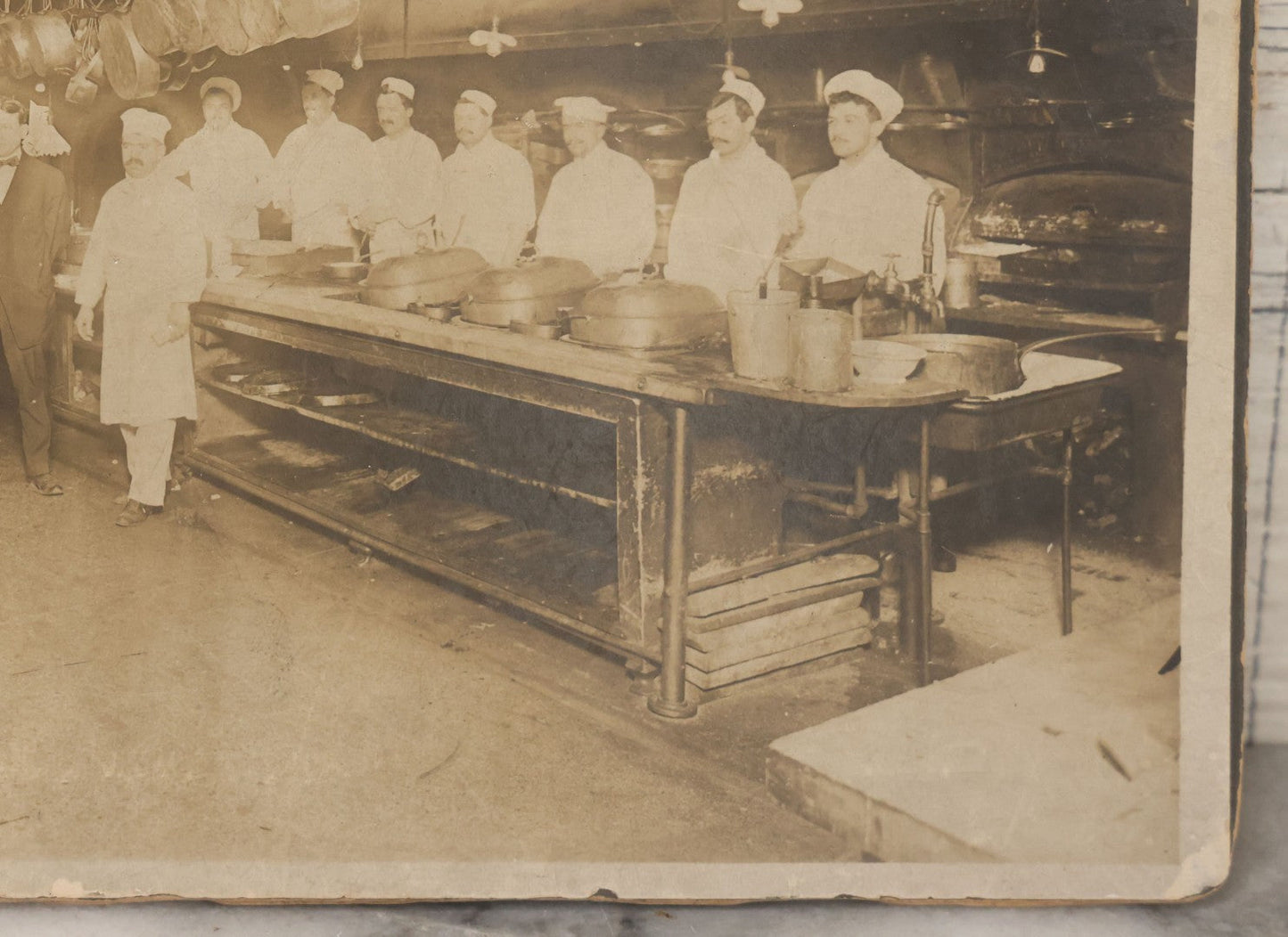 Lot 124 - Antique Boarded Occupational Photograph Of Kitchen Staff At Their Stations In Large Industrial Kitchen With Period Uniforms And Cooking Appliances Visible