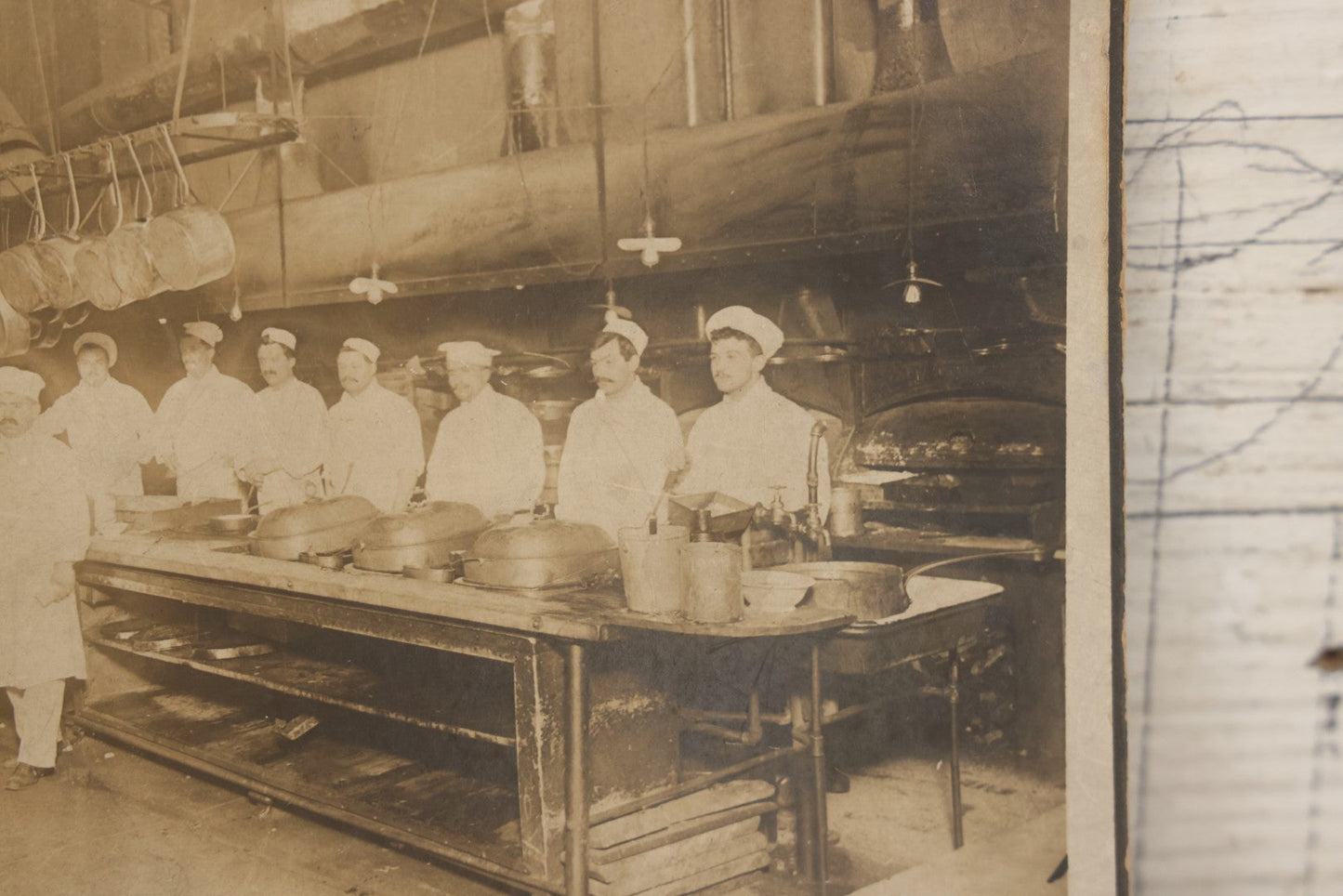 Lot 124 - Antique Boarded Occupational Photograph Of Kitchen Staff At Their Stations In Large Industrial Kitchen With Period Uniforms And Cooking Appliances Visible