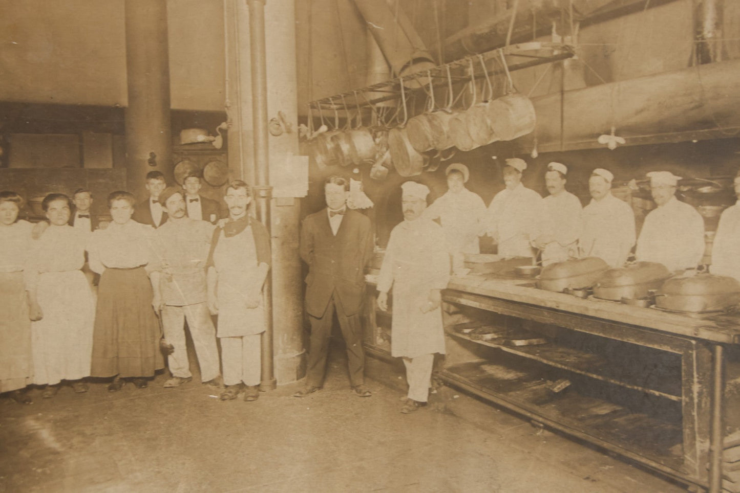 Lot 124 - Antique Boarded Occupational Photograph Of Kitchen Staff At Their Stations In Large Industrial Kitchen With Period Uniforms And Cooking Appliances Visible