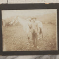 Lot 128 - Antique Boarded Photograph Of An Elderly Cowboy Smoking A Pipe Beside His White Horse