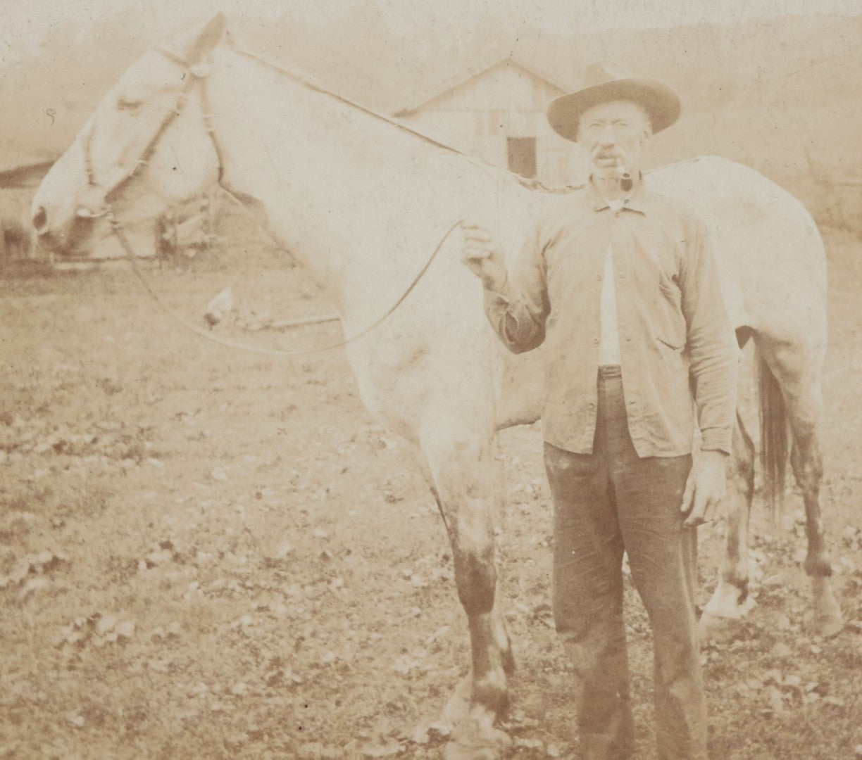Lot 128 - Antique Boarded Photograph Of An Elderly Cowboy Smoking A Pipe Beside His White Horse