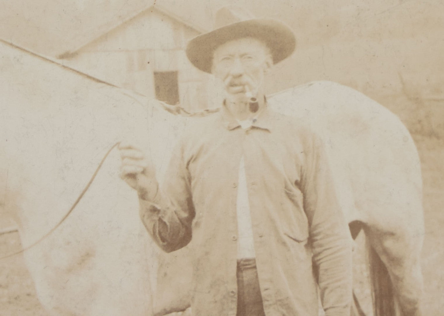 Lot 128 - Antique Boarded Photograph Of An Elderly Cowboy Smoking A Pipe Beside His White Horse