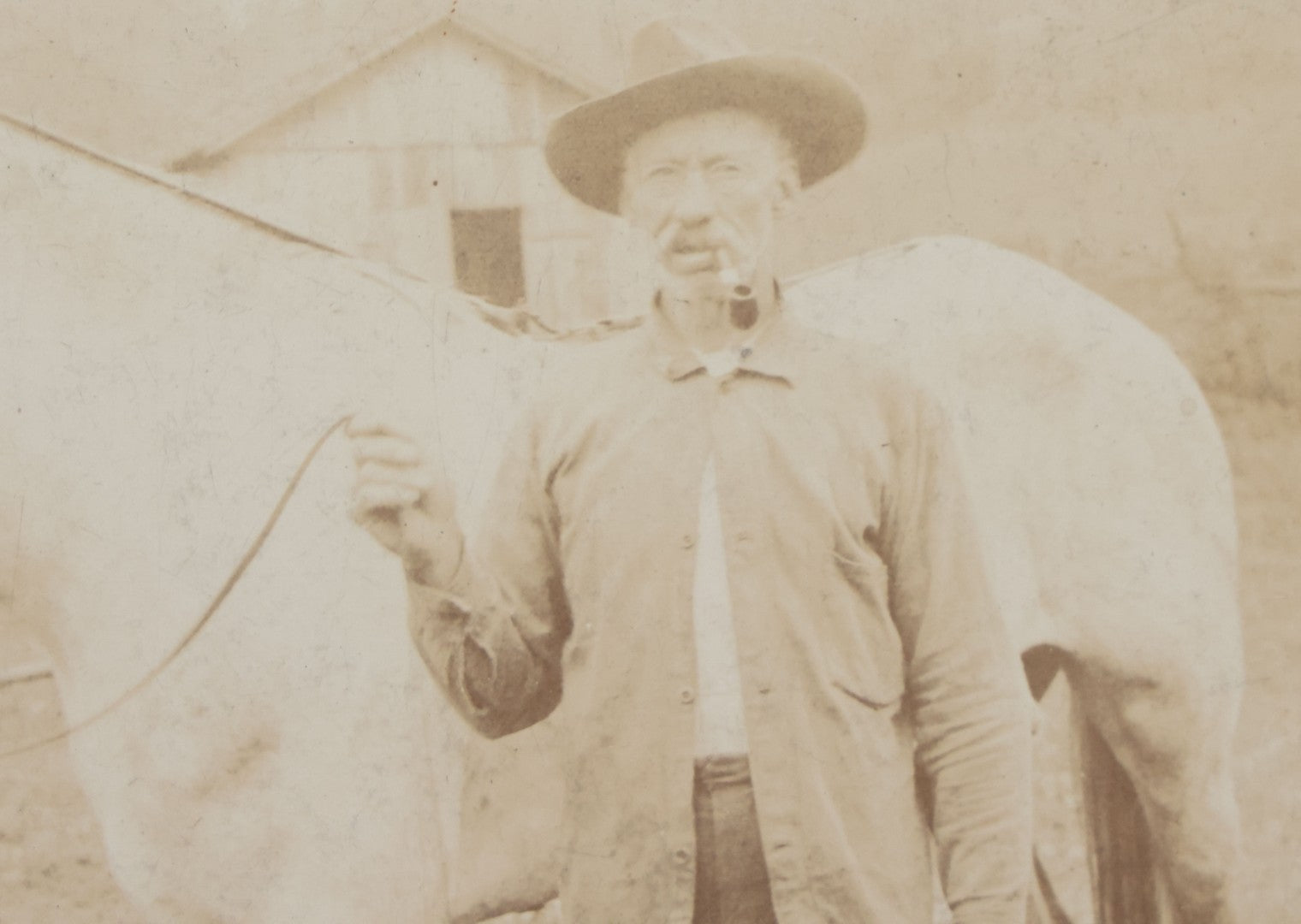 Lot 128 - Antique Boarded Photograph Of An Elderly Cowboy Smoking A Pipe Beside His White Horse