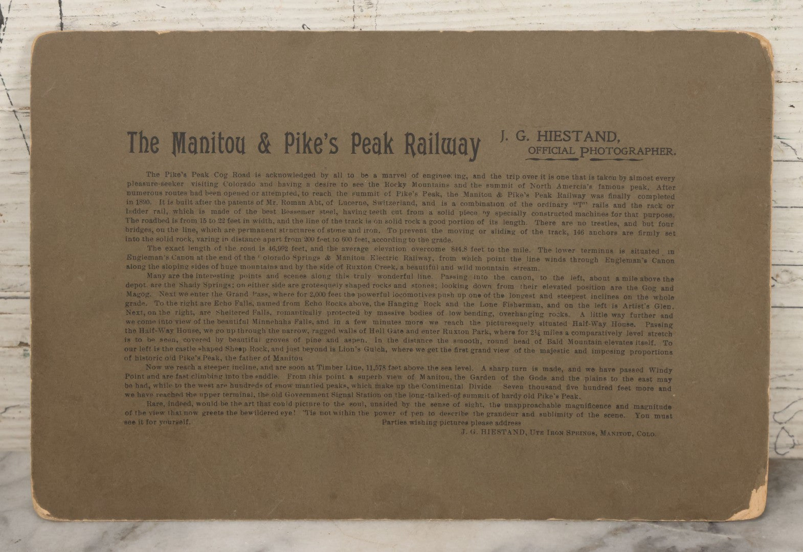 Lot 129 - Antique Boarded Souvenir Photograph Of Travelers Beside Rail Car On The Manitou & Pike's Peak Cog Railway, Rocky Mountains, Colorado, Photo By J.G. Hiestand, Official Photographer, Dated 1907