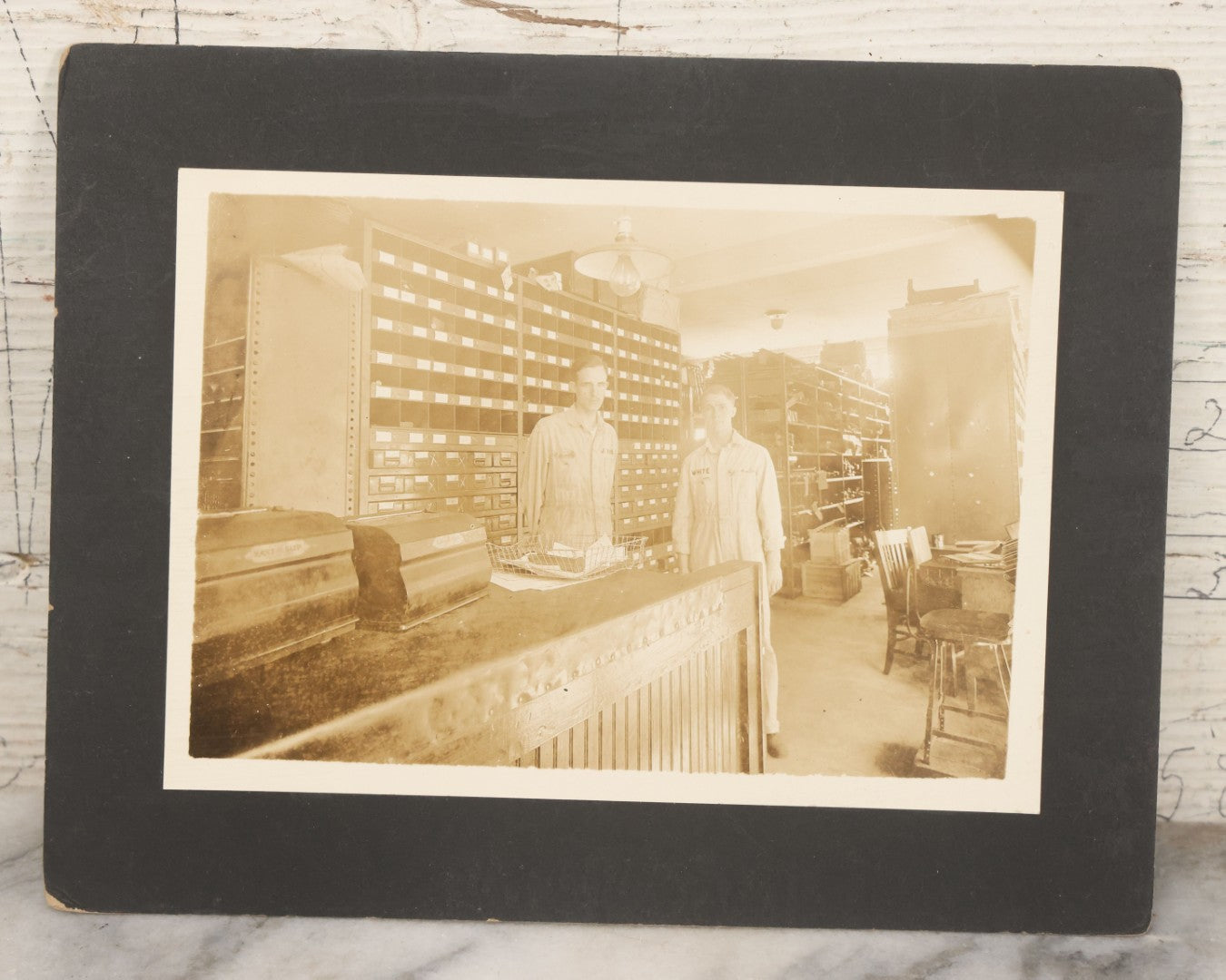 Lot 135 - Antique Boarded Occupational Photograph Of Two Workers In Embroidered Coveralls Working In A Parts Shop 
