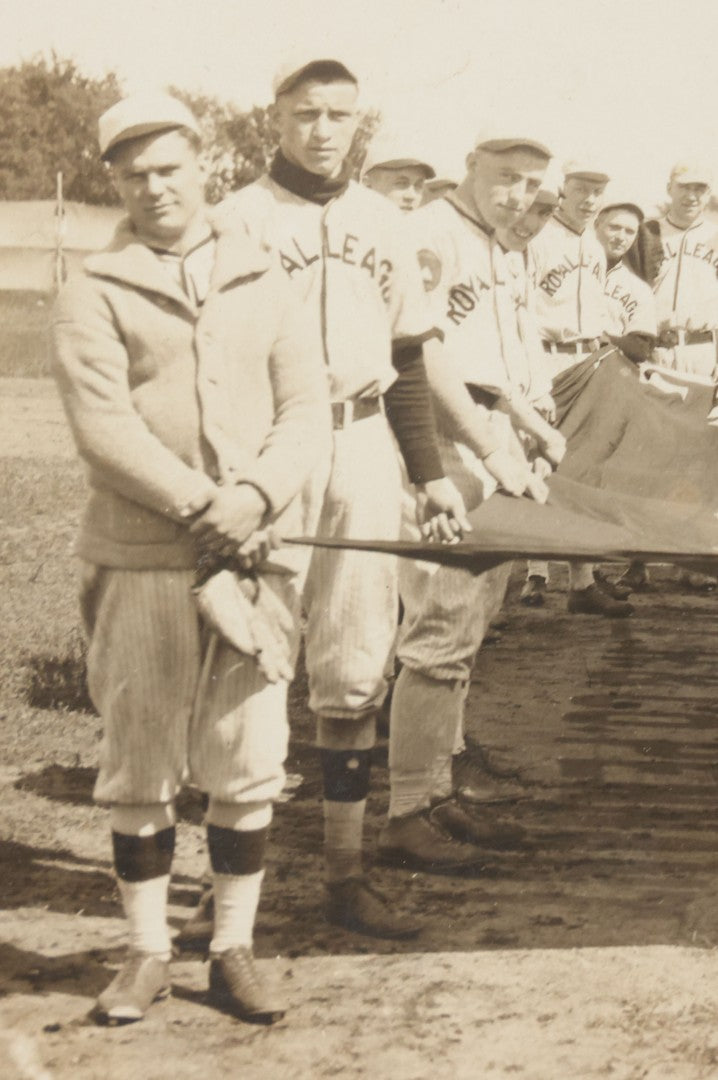 Lot 139 - Antique Boarded Photograph Of The Players Of A Baseball Team In Uniform Posing With A Large Flag, Uniforms Say "Royal League" With Patches Visible