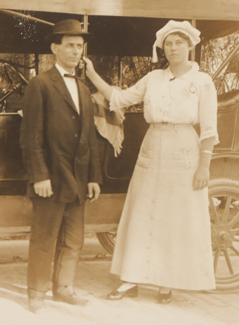 Lot 141 - Pair Of Antique Boarded Photographs Including Man And Woman Couple Posing Beside Early Automobile, Woman Does Not Look Thrilled And Man Seems To Know It, And Man Driving Away Without Her