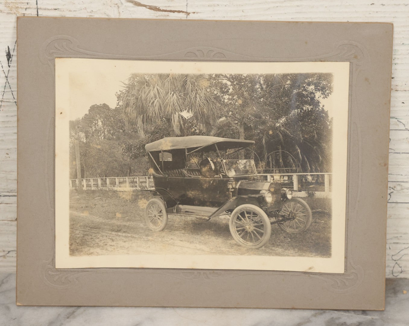 Lot 141 - Pair Of Antique Boarded Photographs Including Man And Woman Couple Posing Beside Early Automobile, Woman Does Not Look Thrilled And Man Seems To Know It, And Man Driving Away Without Her