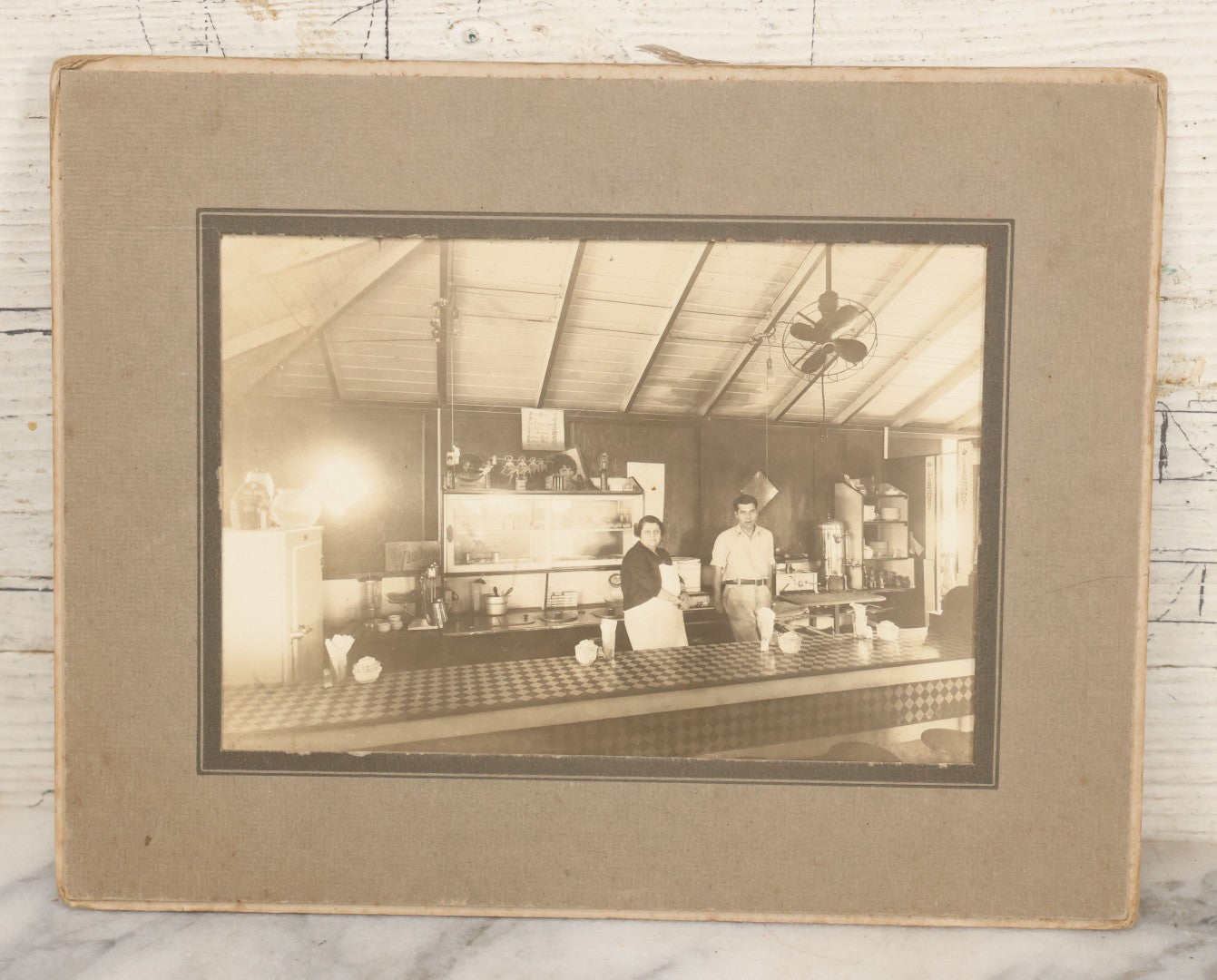 Lot 150 - Vintage Occupational Photograph In Paper Slip Frame Of Man And Woman Working The Counter At A Diner, Identified As "Grandma" And Henry