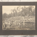 Lot 152 - Antique Boarded Photograph Of Group Of Men Women And Children Walking Through A Barren Deforested Landscape Including Tall Man Posing On Log With Parasol
