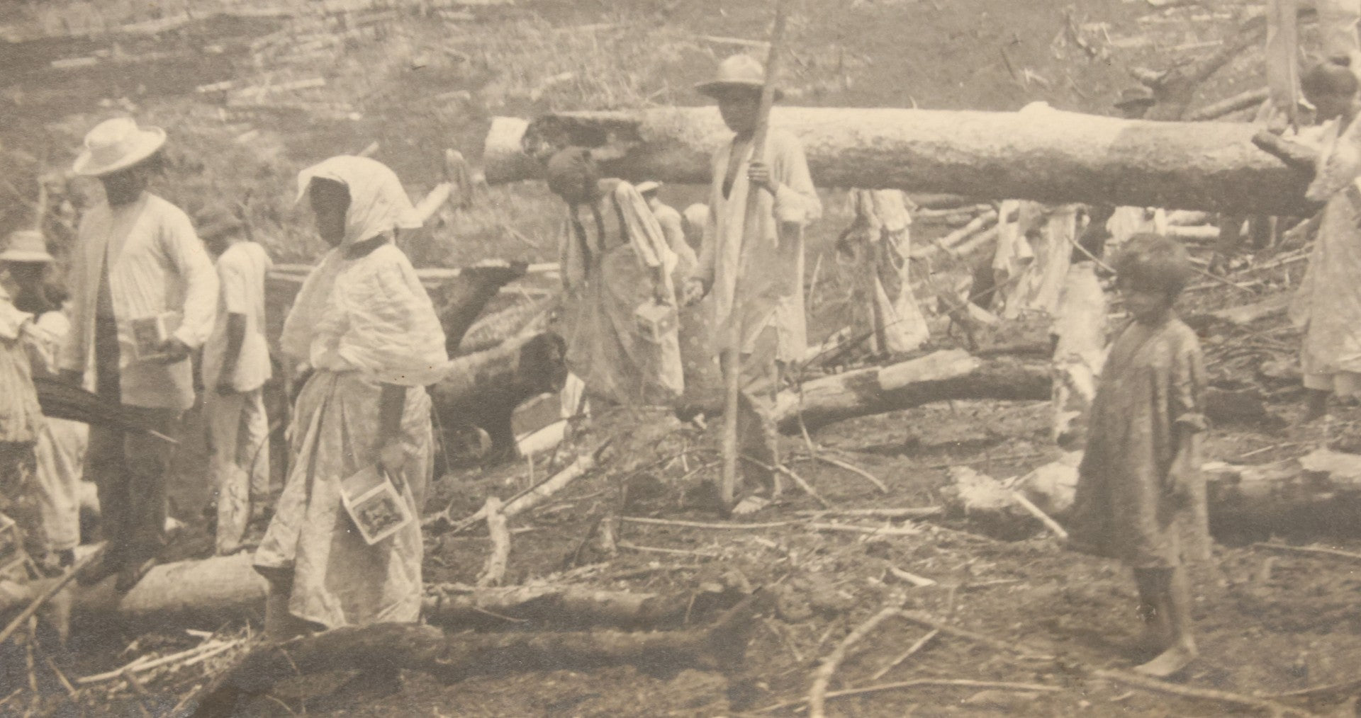 Lot 152 - Antique Boarded Photograph Of Group Of Men Women And Children Walking Through A Barren Deforested Landscape Including Tall Man Posing On Log With Parasol