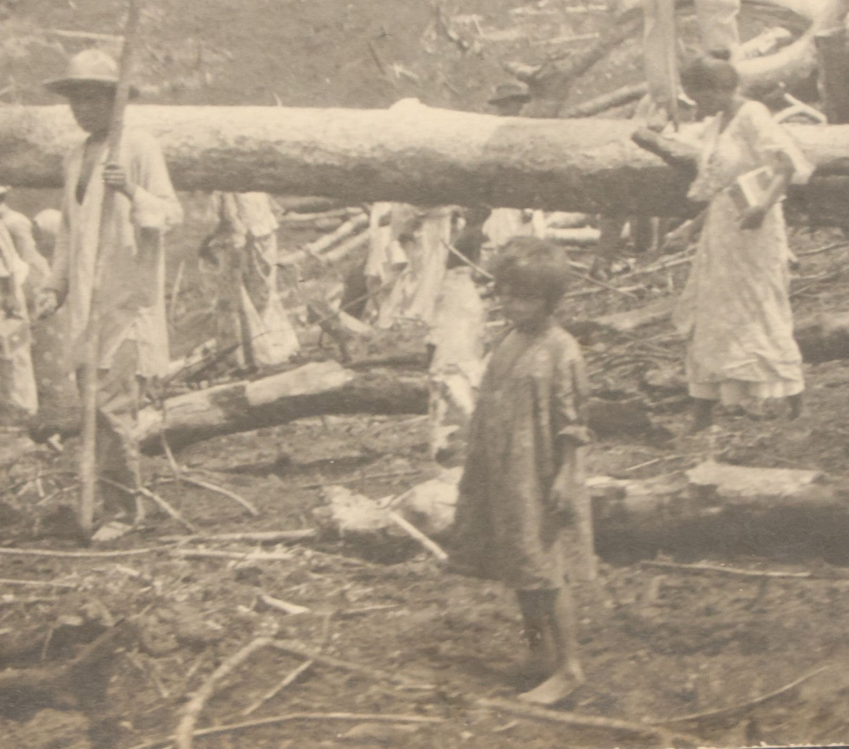 Lot 152 - Antique Boarded Photograph Of Group Of Men Women And Children Walking Through A Barren Deforested Landscape Including Tall Man Posing On Log With Parasol