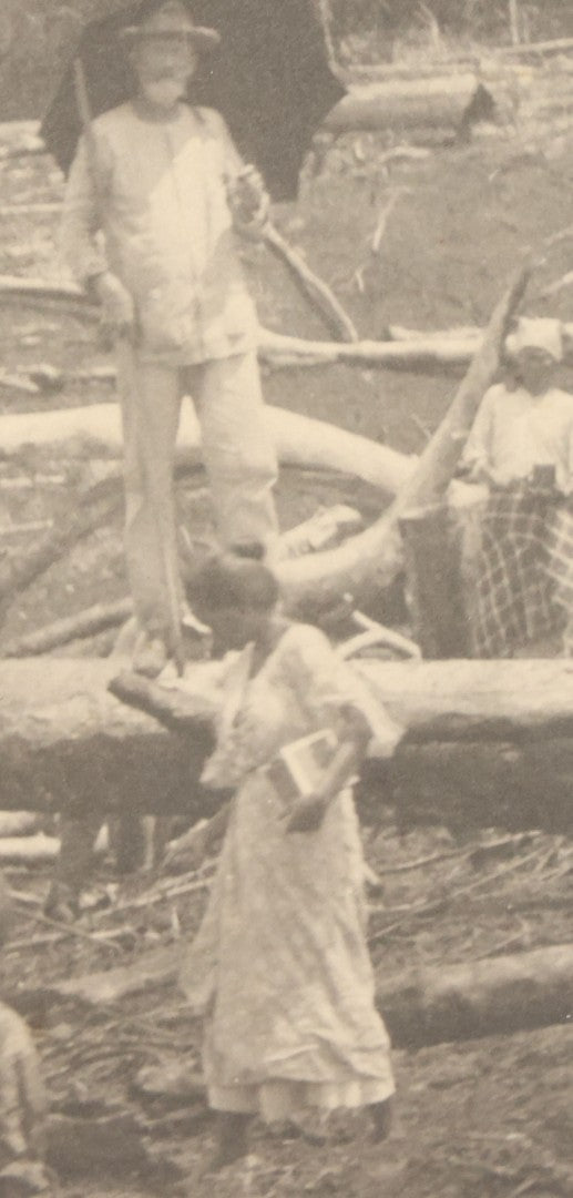 Lot 152 - Antique Boarded Photograph Of Group Of Men Women And Children Walking Through A Barren Deforested Landscape Including Tall Man Posing On Log With Parasol