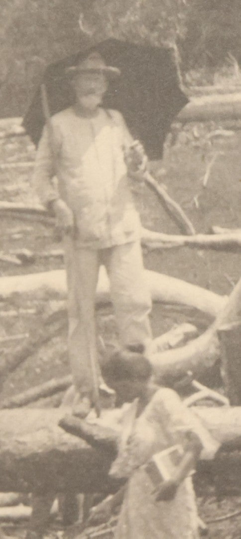 Lot 152 - Antique Boarded Photograph Of Group Of Men Women And Children Walking Through A Barren Deforested Landscape Including Tall Man Posing On Log With Parasol