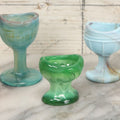 Lot 023 - Grouping Of Seven Vintage Colorful Swirled Slag Glass Eye Wash Cups, Including Cadmium, Other Black Light Reactive Colors, Blue, Green, Red, Etc., As Seen, Up To 2-5/8" Height