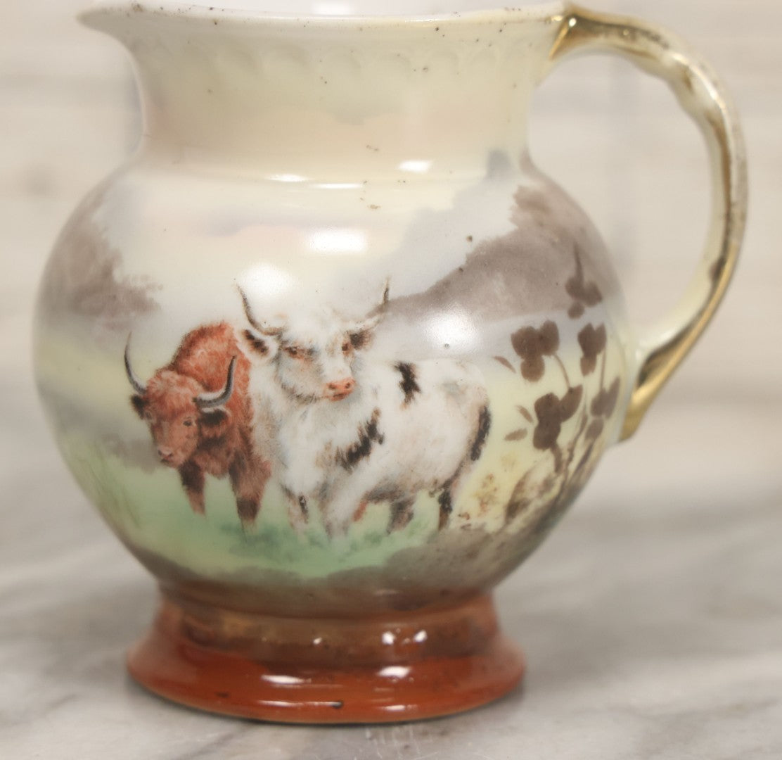 Lot 088 - Antique Royal Bayreuth Porcelain Creamer With White And Brown Cow Graphics, Painted Landscape Scene, 3-5/8" Height