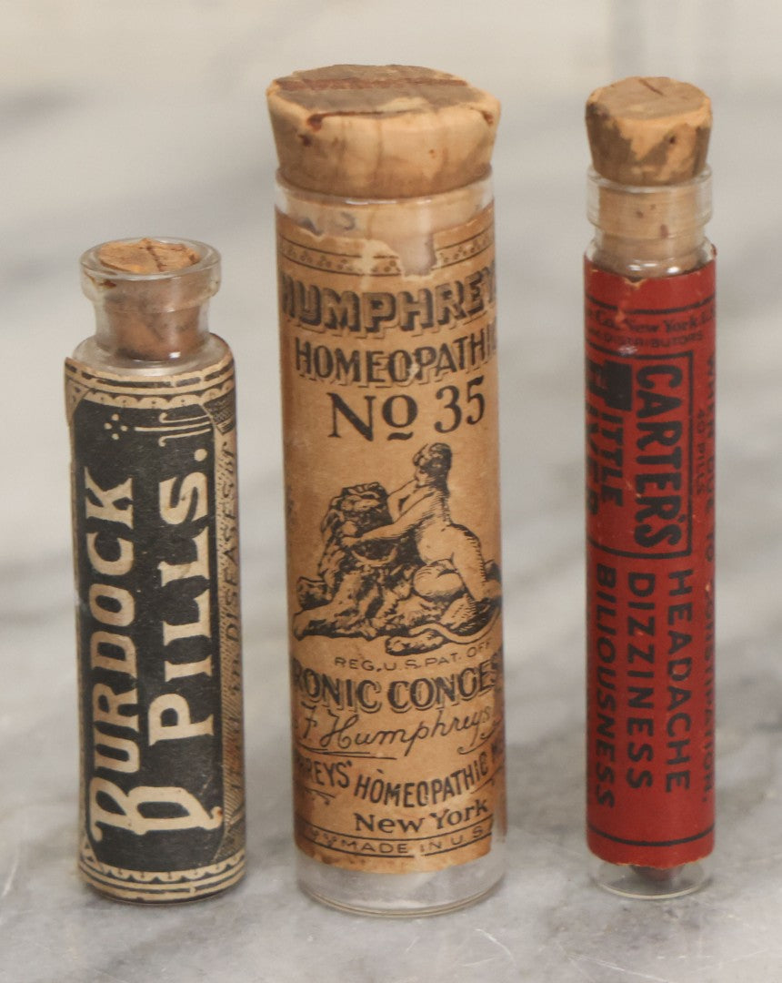 Lot 100 - Grouping Of Three Antique Medicine Pill Vials With Original Paper Labels, Corks, And Contents, Including Humphrey's Homeopathic No. 35., Burdock Pills, And Cartier's Little Liver Pills