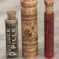 Lot 100 - Grouping Of Three Antique Medicine Pill Vials With Original Paper Labels, Corks, And Contents, Including Humphrey's Homeopathic No. 35., Burdock Pills, And Cartier's Little Liver Pills