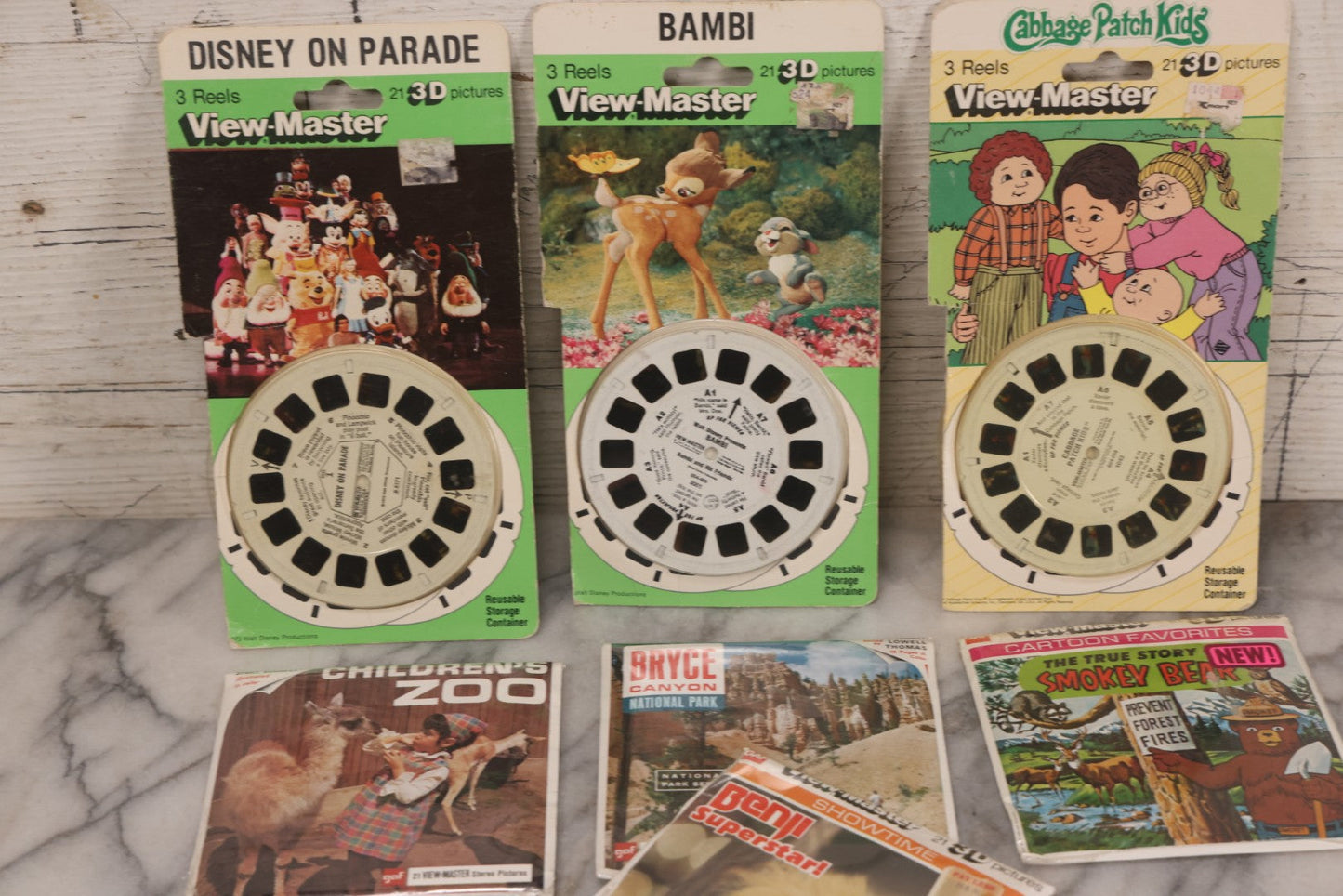 Lot 115 - Thirteen Piece Vintage Sealed Viewmaster Stereoview 3D Discs Including Cabbage Patch Kids, Bambi, Disney On Parade, Smokey Bear, And Many Travel Editions