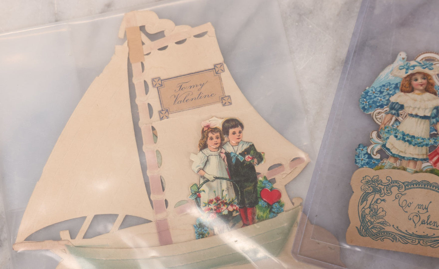 Lot 118 - Pair Of Antique Die Cut Valentines Including Two Girls In Colorful Dresses And Young Couple On Sailboat