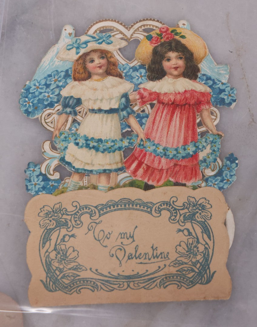 Lot 118 - Pair Of Antique Die Cut Valentines Including Two Girls In Colorful Dresses And Young Couple On Sailboat