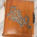 Lot 012 - Antique Victorian Photo Album With Wood Cover And Silverplate Emblem, Containing Twenty Antique Photographs Of Various Types, Including Man In Office, Children With Pram, Man With White Beard, Note Binding Wear Cover Loosening