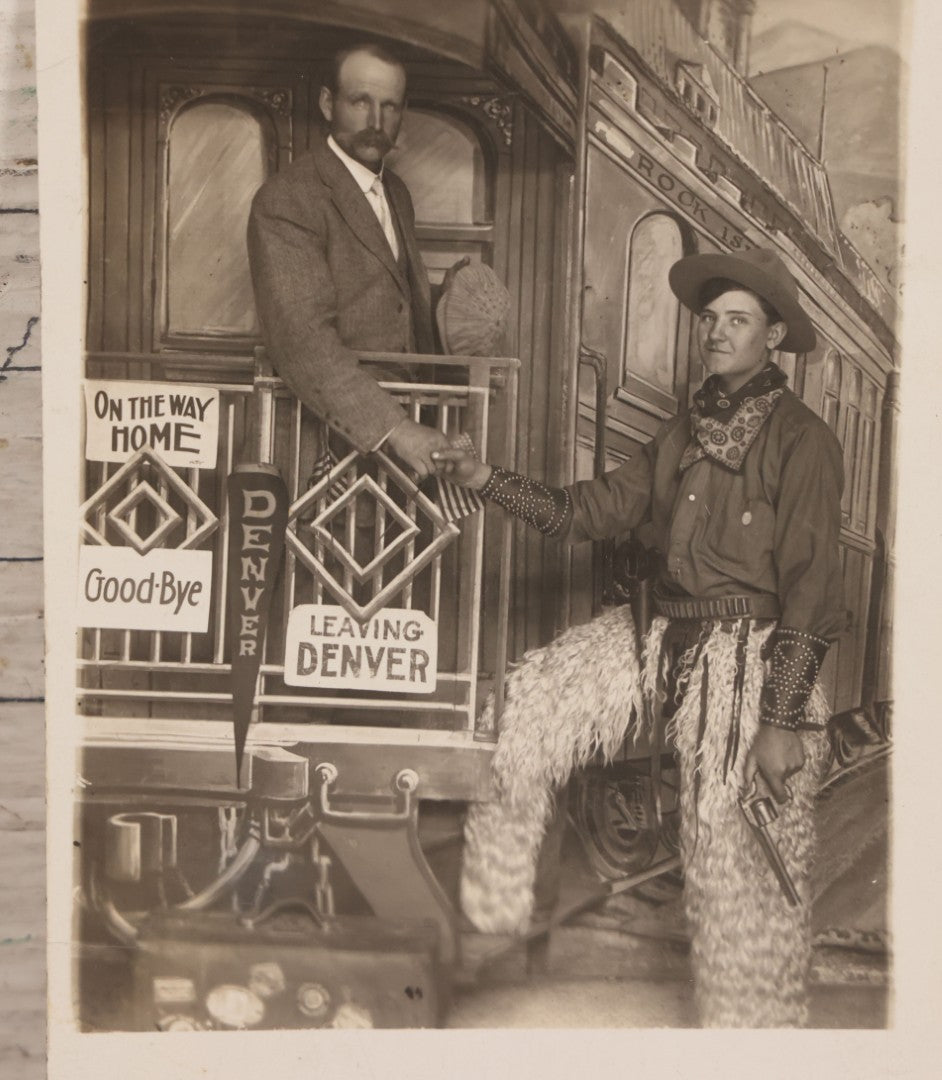 Lot 083 - Antique Real Photo Postcard R.P.P.C. Showing Young Man Dressed As Cowboy Shaking Hands With Older Man On Faux Train Photography Set In Denver, Colorado