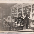 Lot 093 - Antique Large Format Photograph Of Elderly Pharmacist Compounding Medicine At The Pharmacy Counter, With Many Apothecary Bottles And Tools Visible