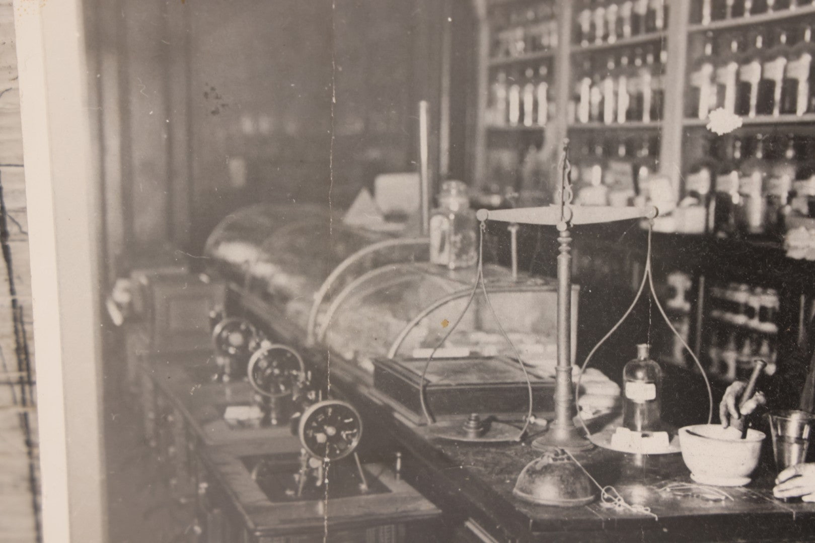 Lot 093 - Antique Large Format Photograph Of Elderly Pharmacist Compounding Medicine At The Pharmacy Counter, With Many Apothecary Bottles And Tools Visible