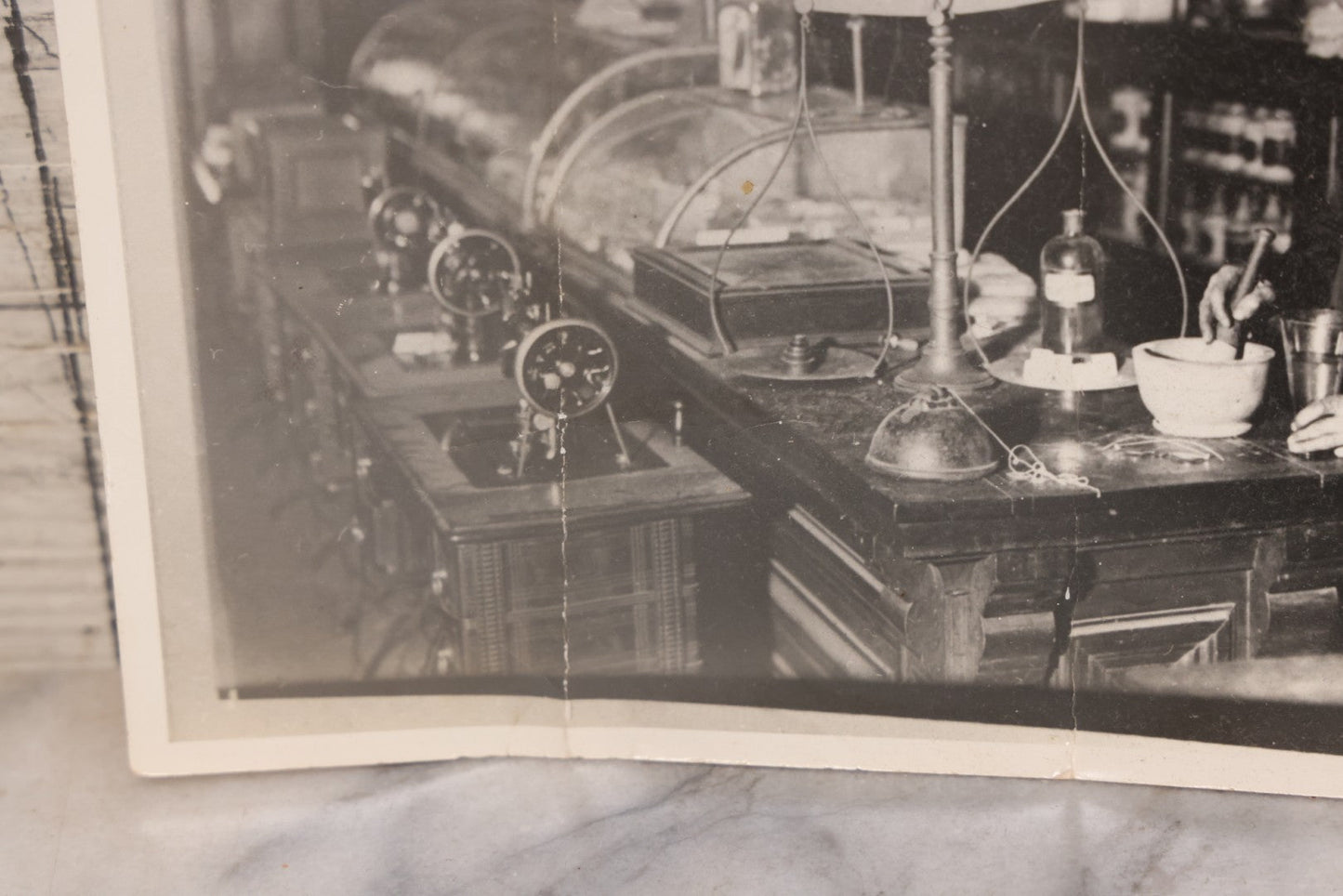 Lot 093 - Antique Large Format Photograph Of Elderly Pharmacist Compounding Medicine At The Pharmacy Counter, With Many Apothecary Bottles And Tools Visible