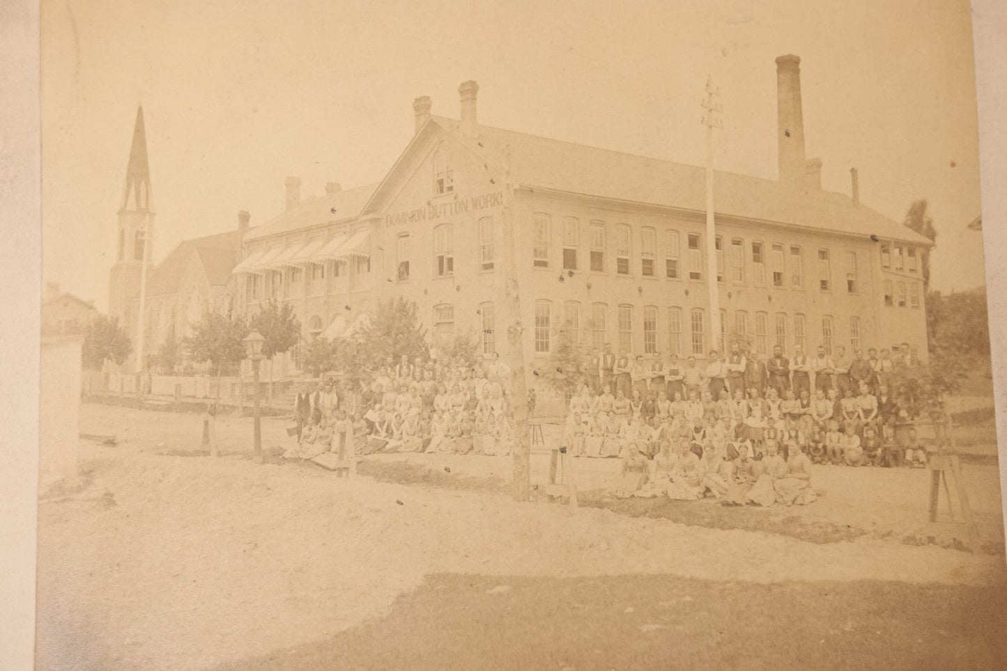 Lot 112 - Antique Boarded Occupational Photograph Of Large Group Of Workers Of The Dominion Button Works Factory, Ontario, Canada