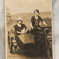 Lot 072 - Antique Real Photo Postcard R.P.P.C. Of Two Women Posing On An Early Indian Motorcycle With Sidecar, Woman In Hat Holding Kewpie Doll
