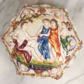 Lot 105 - Vintage Capodimonte Style Porcelain Lidded Box With Three Graces Relief And Cherub Masks, 2-5/8" H