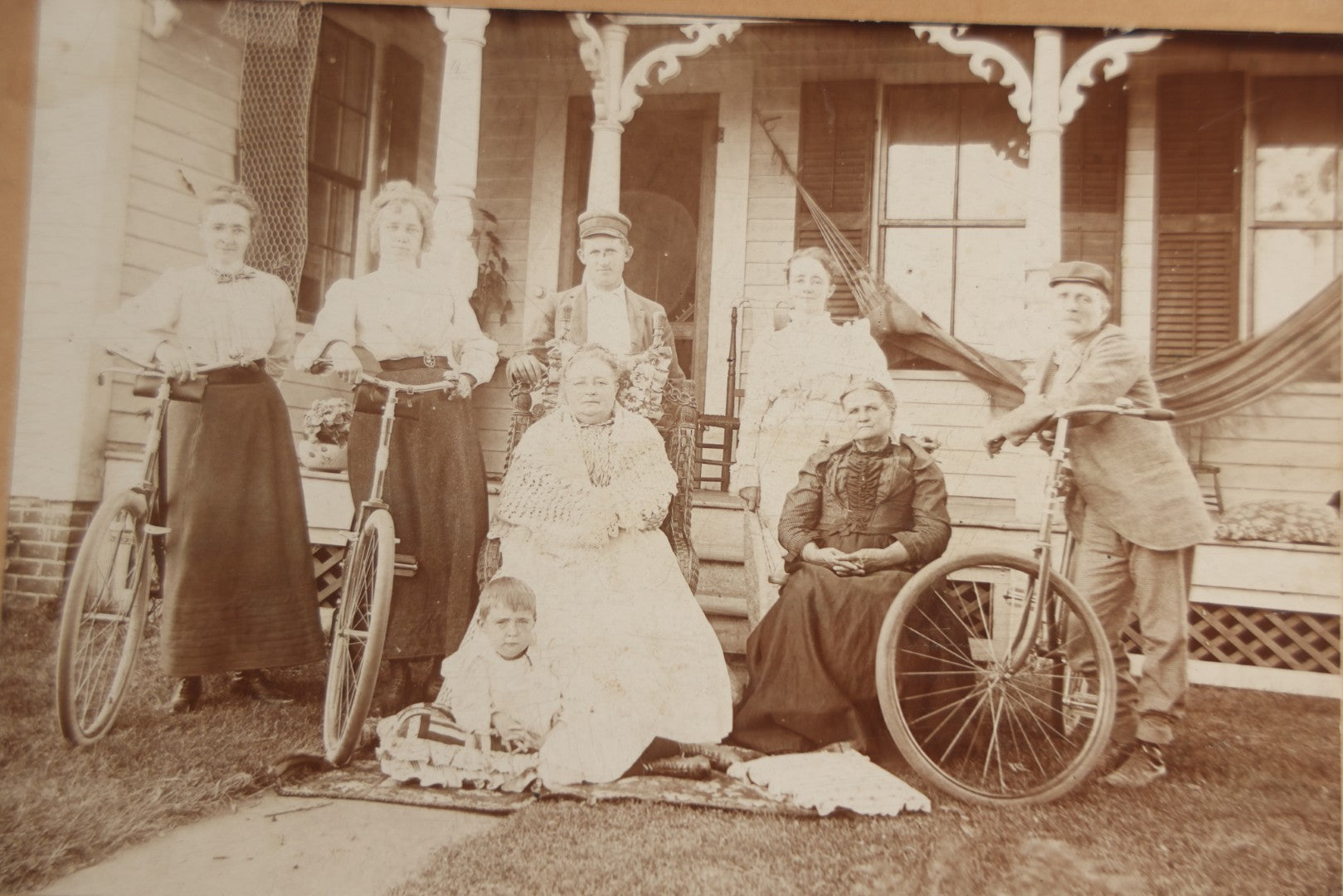 Lot 126 - Antique Boarded Photograph Of Men And Women Posing With Bicycles In Front Of Porch With Hammock, Identified On Verso