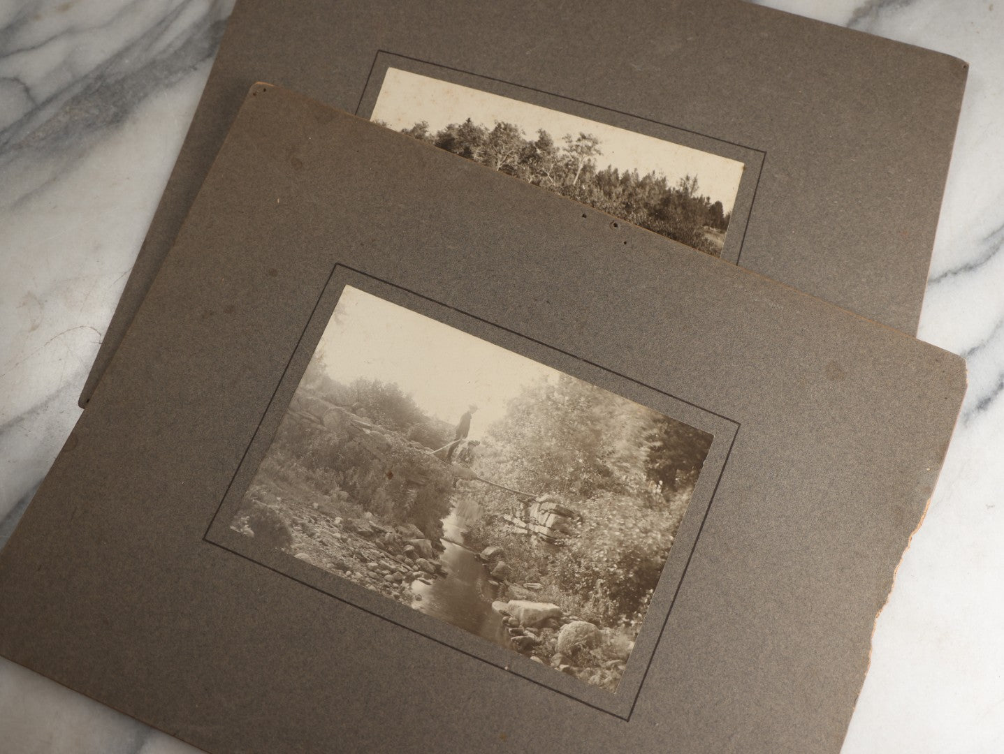Lot 131 - Pair Of Antique Boarded Photographs Of Outdoor Scenes, Including Boy And Girl On Primitive Stick Bridge Crossing Creek, Canoe