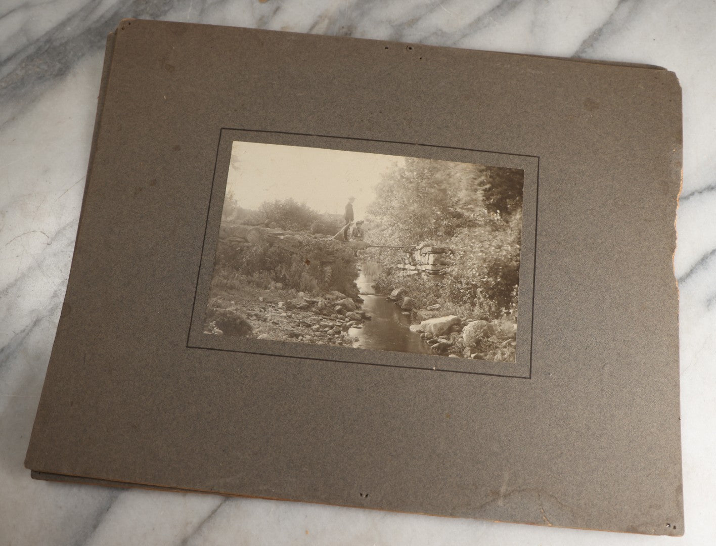 Lot 131 - Pair Of Antique Boarded Photographs Of Outdoor Scenes, Including Boy And Girl On Primitive Stick Bridge Crossing Creek, Canoe