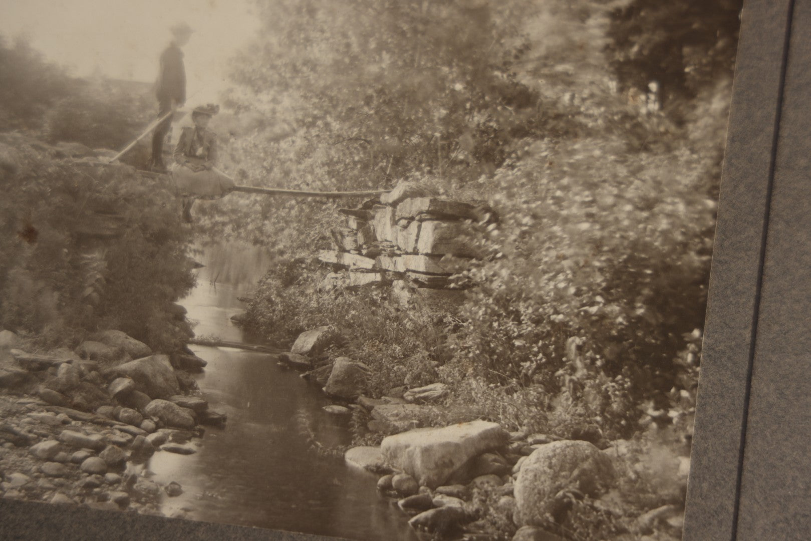 Lot 131 - Pair Of Antique Boarded Photographs Of Outdoor Scenes, Including Boy And Girl On Primitive Stick Bridge Crossing Creek, Canoe