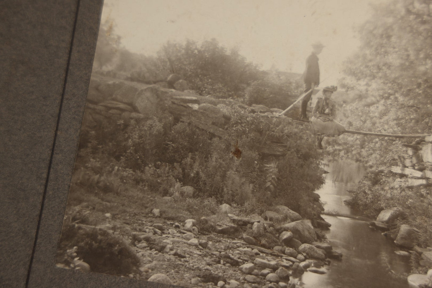 Lot 131 - Pair Of Antique Boarded Photographs Of Outdoor Scenes, Including Boy And Girl On Primitive Stick Bridge Crossing Creek, Canoe