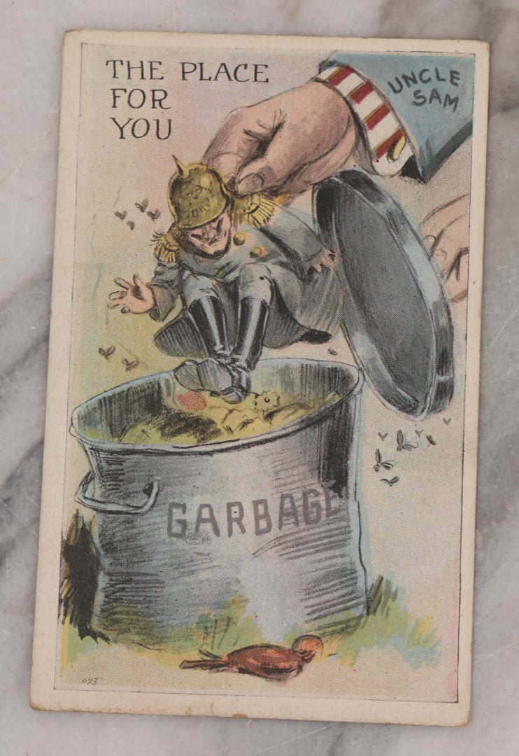 Lot 082 - Grouping Of Five Antique World War One Era Postcards Documenting The War Including Comic Illustration, Uncle Sam Placing Kaiser In Garbage, Soldier Shaving, Tank In Action, Motorcycle Ambulance, And Rifle Practice