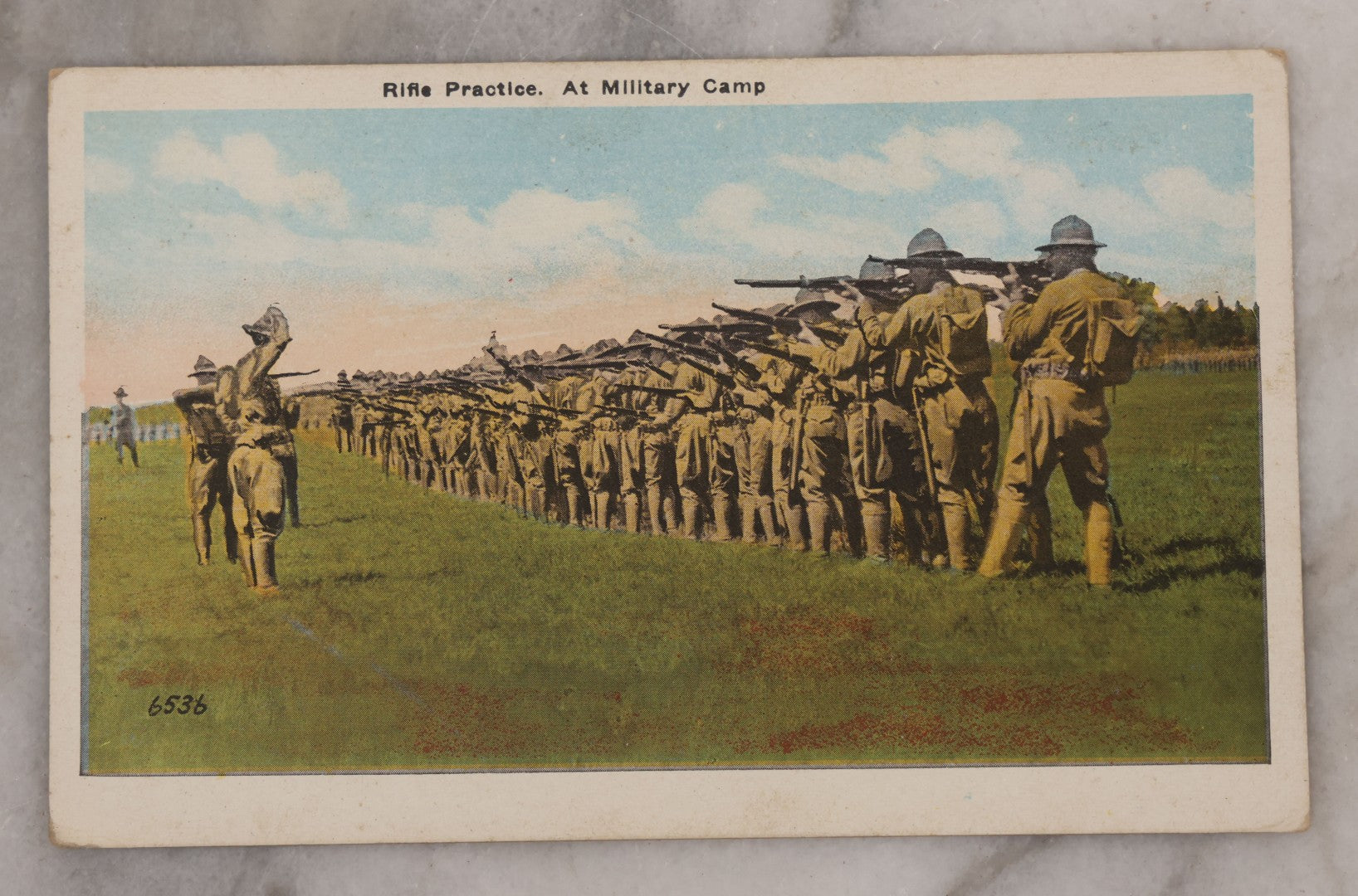 Lot 082 - Grouping Of Five Antique World War One Era Postcards Documenting The War Including Comic Illustration, Uncle Sam Placing Kaiser In Garbage, Soldier Shaving, Tank In Action, Motorcycle Ambulance, And Rifle Practice