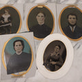 Lot 087 - Grouping Of Five Full Plate Portrait Tintypes Of Men, Women And Children, With Oval Cut Paper Frames With Gold Painted Border, Including Four Hand Colored Photos