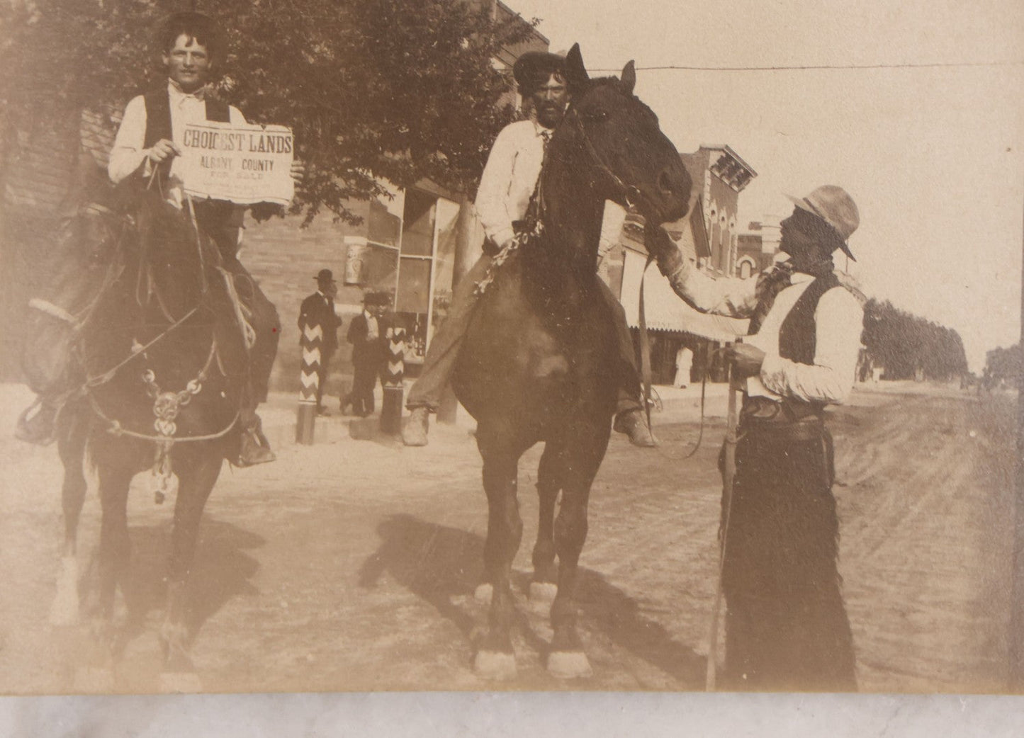 Lot 097 - Grouping Of Three Antique Unmounted Paper Photographs Of Men Posing In And Around Albany County, New York, Including With Horses, In Front Of Confectionary Shop, And Holding Paper With Headline "Choicelest Lands, Albany County"