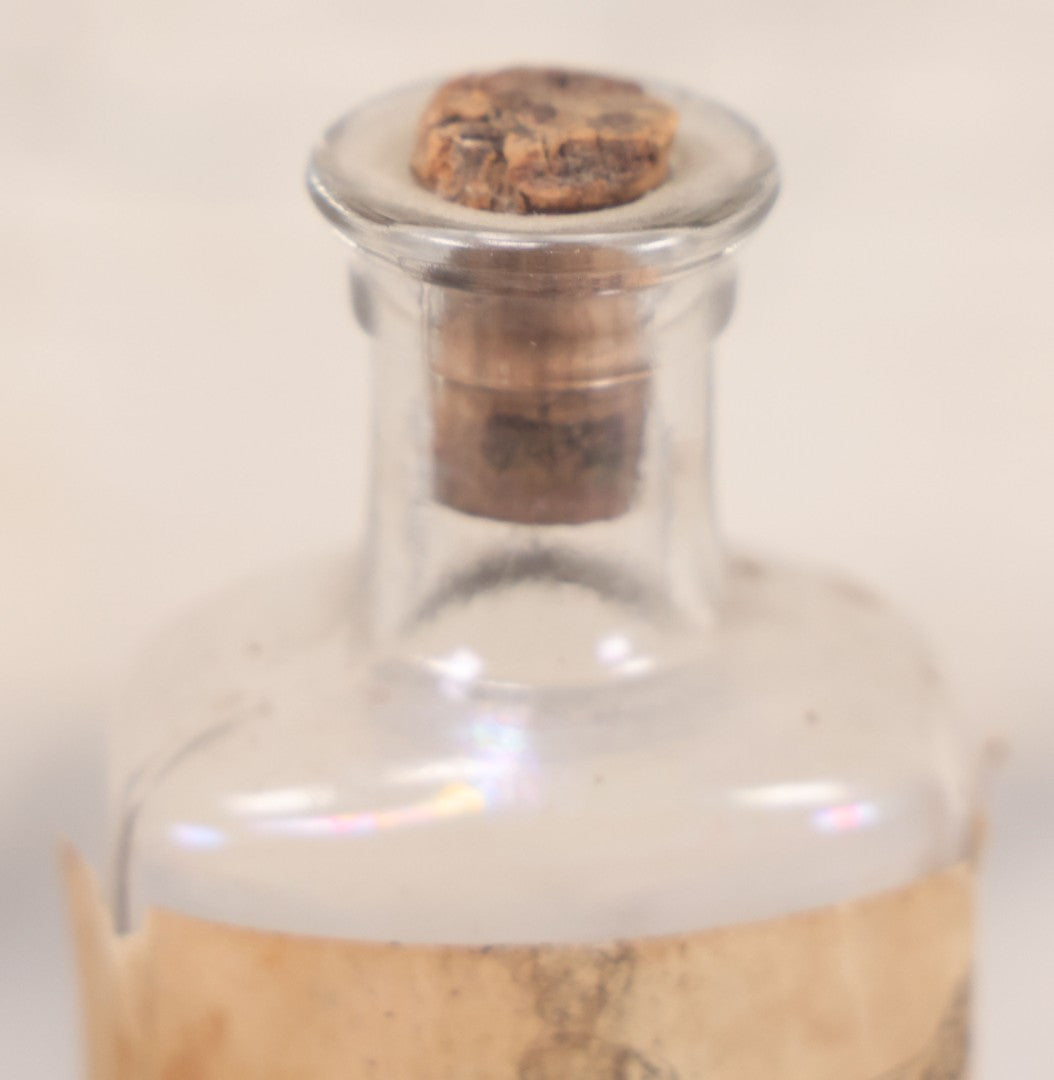 Lot 060 - Antique Clear Glass Bottle With Paper Label “It Beats The Devil” Showing Devil Race Graphics, Arthur N. Roe, Branchville, New Jersey, 5-1/2" H